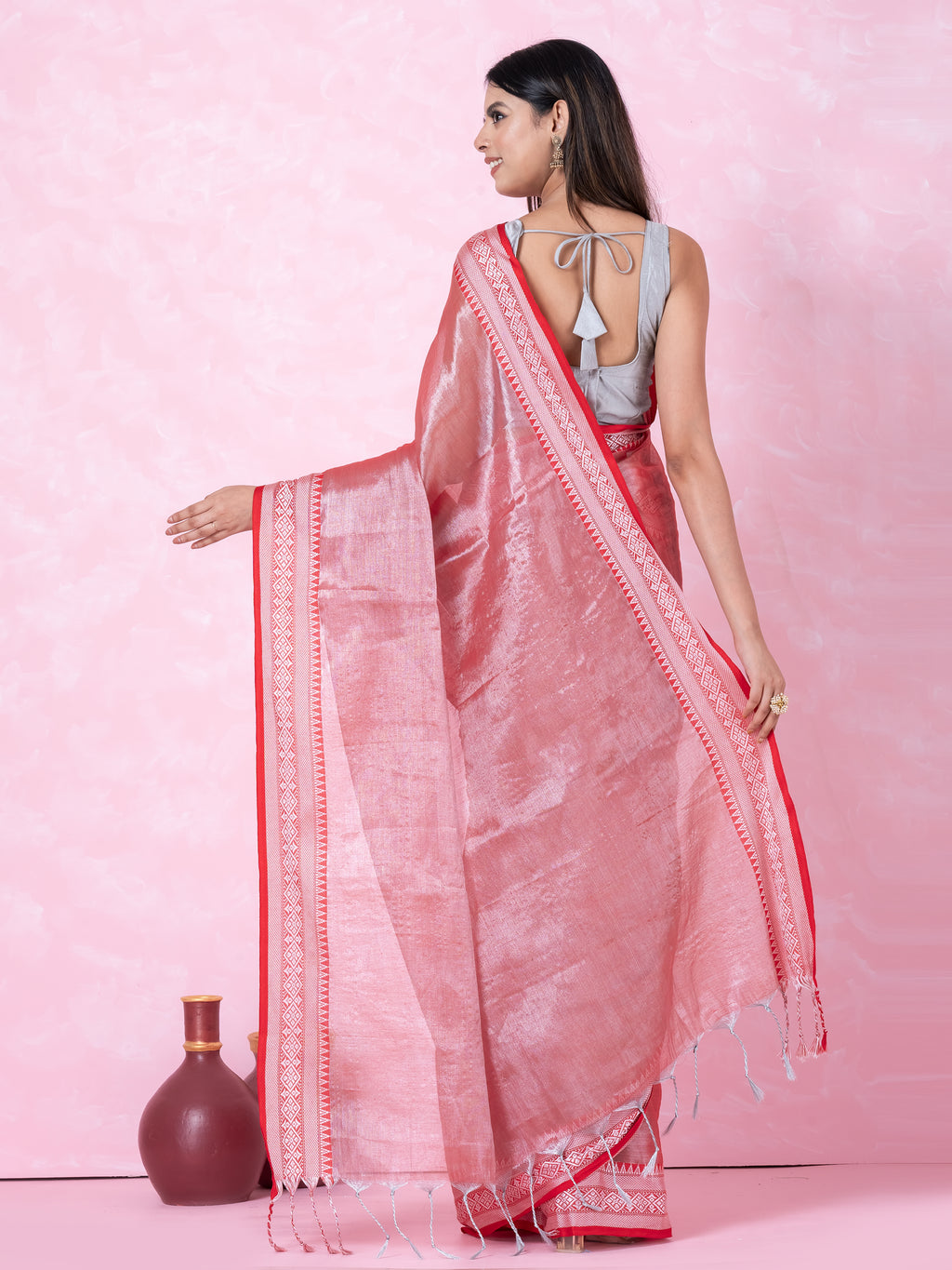 Shimmery red tissue saree with geometrical border.
