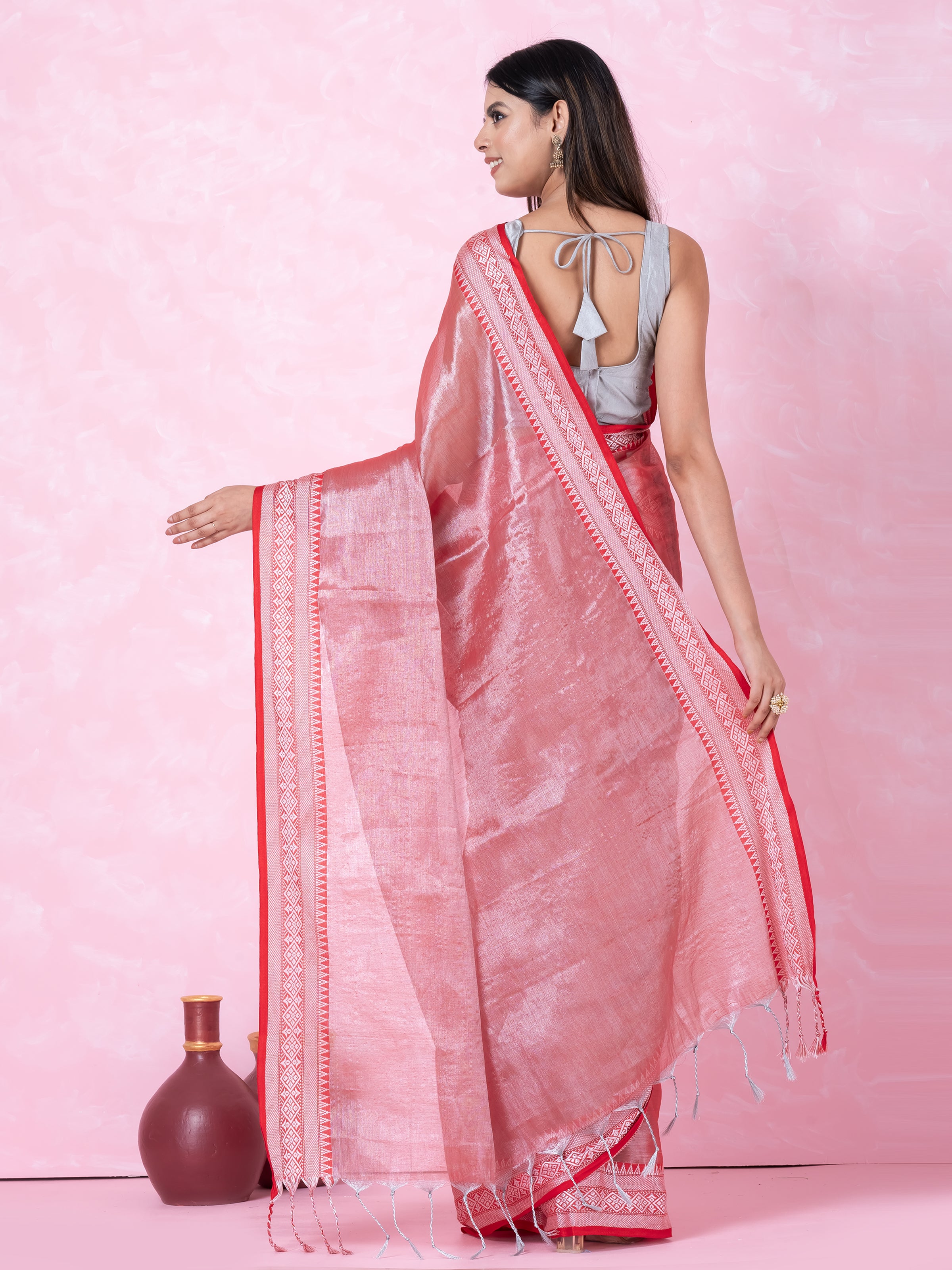Shimmery red tissue saree with geometrical border.