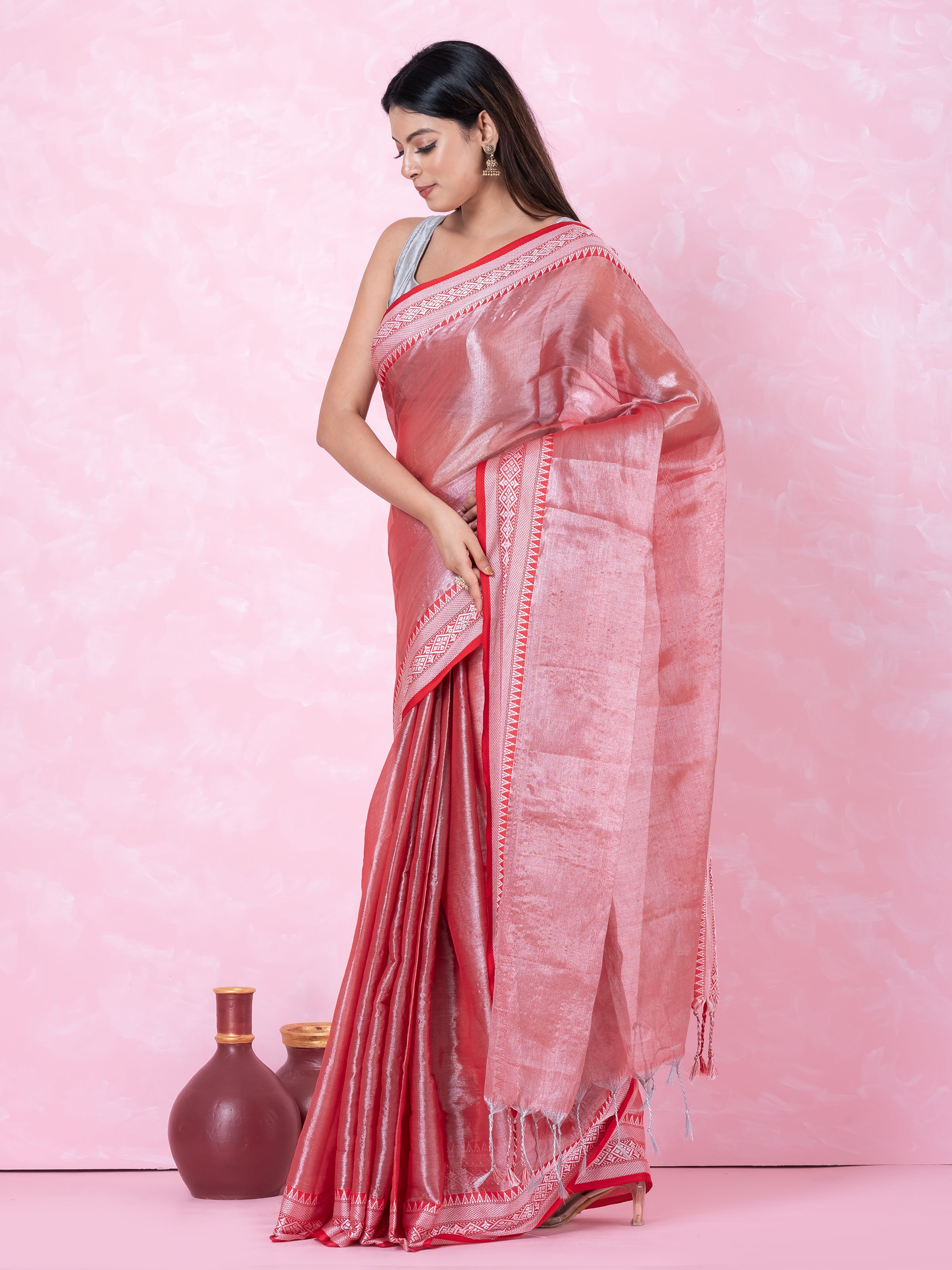 Shimmery red tissue saree with geometrical border.